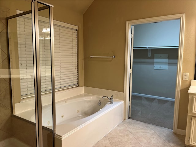 bathroom with a stall shower, tile patterned flooring, a spacious closet, and a whirlpool tub