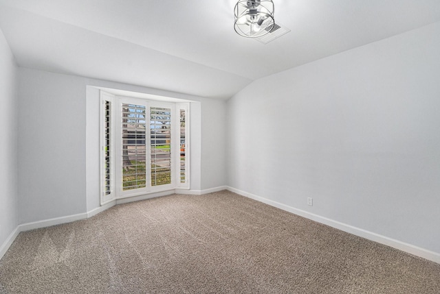 unfurnished room featuring vaulted ceiling, carpet flooring, visible vents, and baseboards