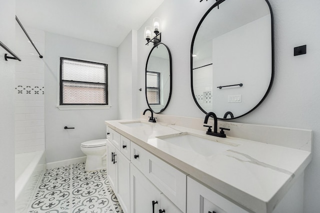 bathroom with double vanity, a sink, toilet, and tile patterned floors