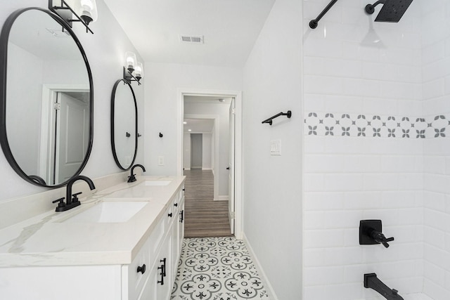 bathroom with walk in shower, visible vents, a sink, and double vanity