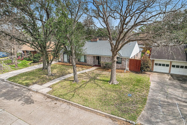 view of front of home with a garage, a front yard, brick siding, and fence