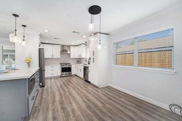 kitchen with stainless steel appliances, wall chimney exhaust hood, decorative backsplash, and crown molding