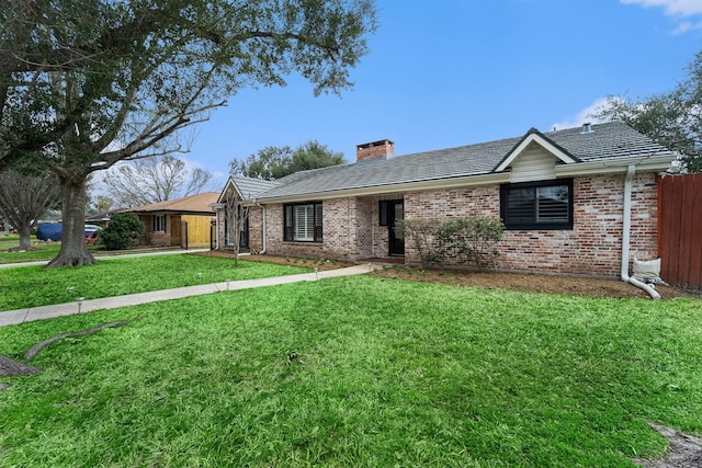 ranch-style house with a front yard, brick siding, fence, and a chimney