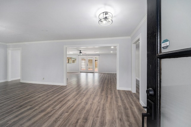 unfurnished living room featuring crown molding, baseboards, dark wood-style flooring, and french doors