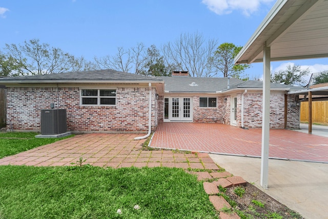 rear view of property featuring french doors, a patio area, brick siding, and central AC unit