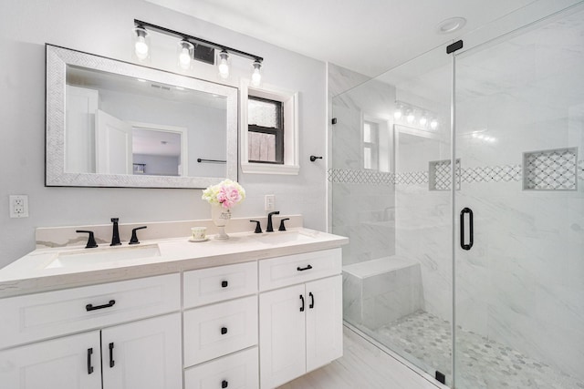 full bathroom featuring double vanity, a sink, and a shower stall