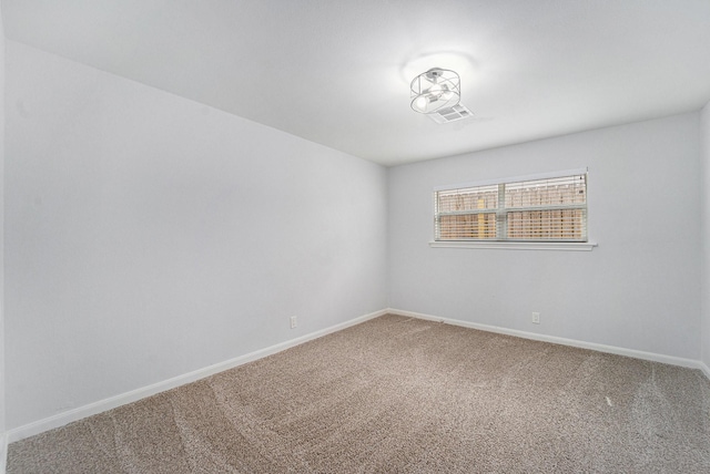 carpeted empty room featuring visible vents and baseboards