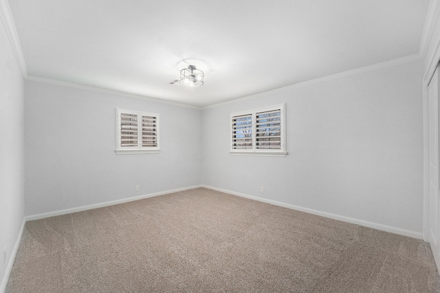 carpeted spare room with baseboards and crown molding