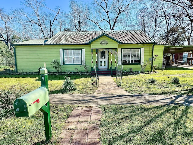 view of front of property featuring metal roof and a front yard