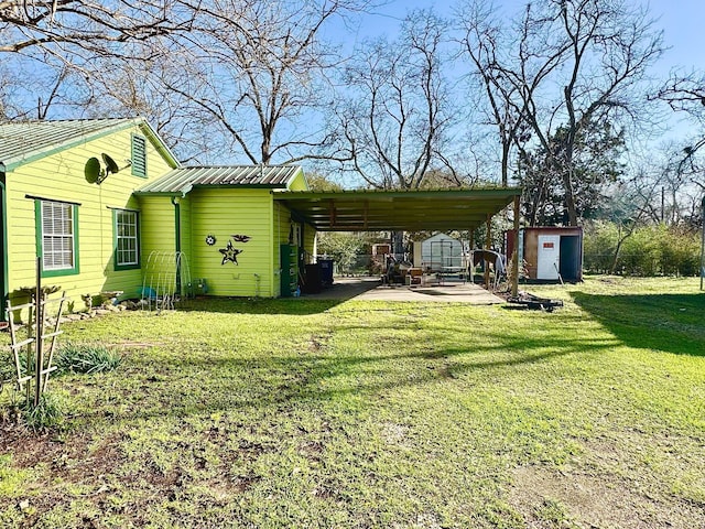 view of yard featuring driveway, a storage unit, and an outdoor structure