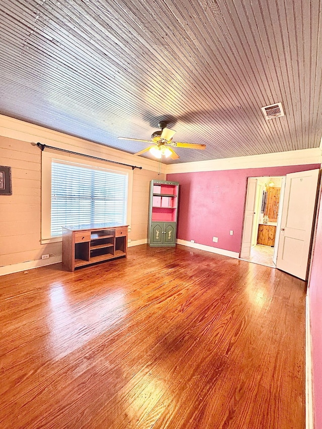 unfurnished living room featuring wooden ceiling, wood finished floors, visible vents, and baseboards