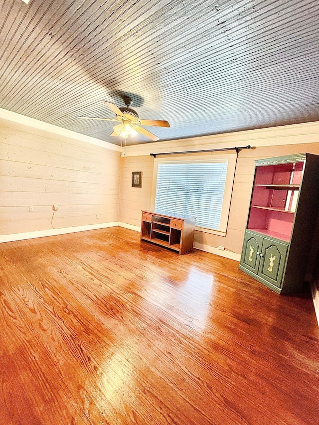 unfurnished living room with ceiling fan, baseboards, and wood finished floors