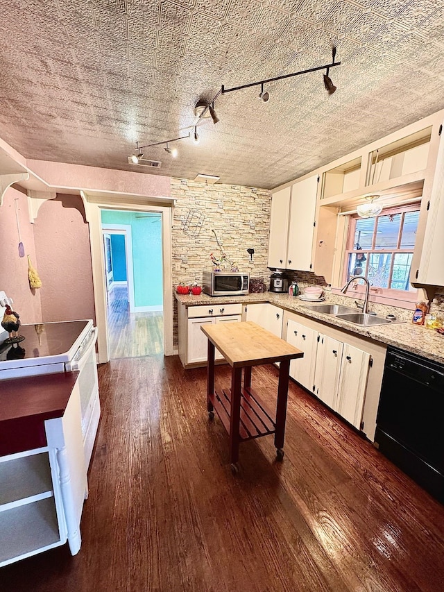 kitchen with black dishwasher, stainless steel microwave, dark wood-type flooring, light countertops, and a sink