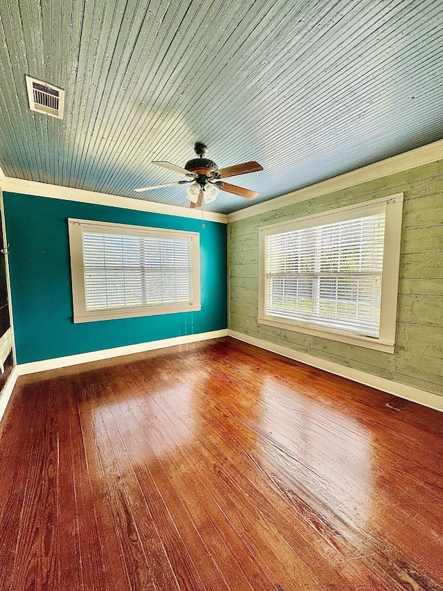 unfurnished room featuring a wealth of natural light, hardwood / wood-style floors, wooden ceiling, and visible vents