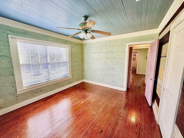 empty room with wooden ceiling, wood walls, ceiling fan, and wood finished floors