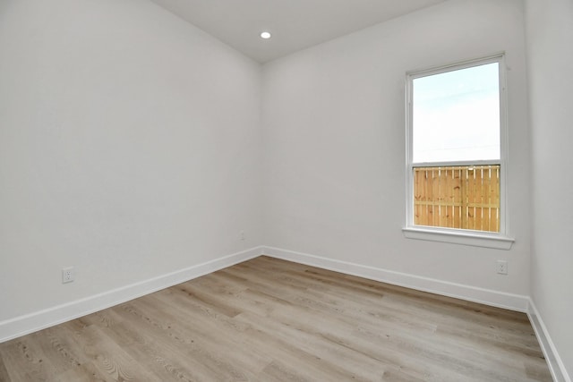 spare room with light wood-type flooring, baseboards, and recessed lighting