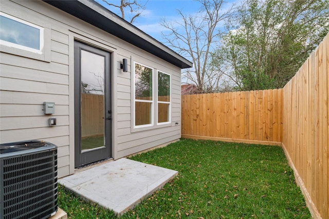 view of yard with central AC and fence