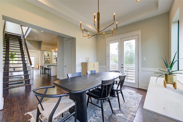 dining area with dark wood-style floors, french doors, a tray ceiling, and stairway