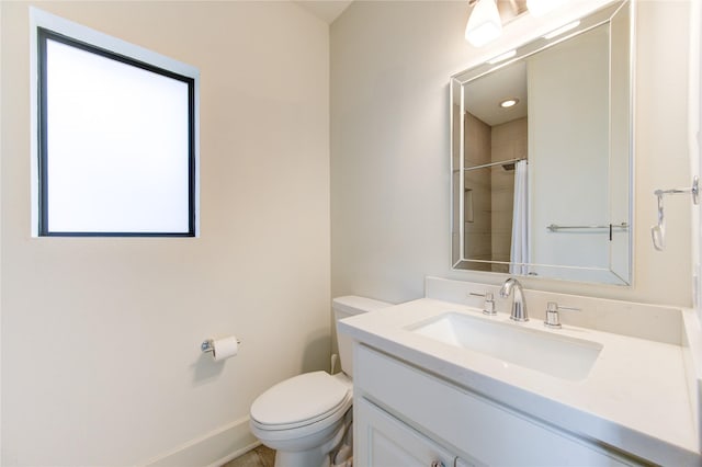 bathroom with toilet, a shower with curtain, baseboards, and vanity