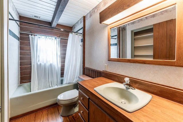 bathroom with beam ceiling, shower / bath combination with curtain, toilet, vanity, and wood finished floors