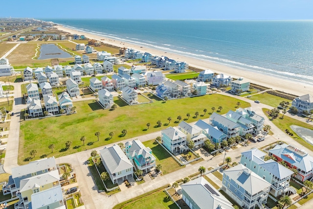 bird's eye view featuring a view of the beach, a water view, and a residential view