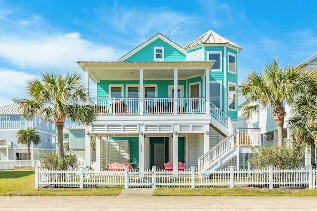 view of front of property with a fenced front yard, covered porch, metal roof, and a standing seam roof