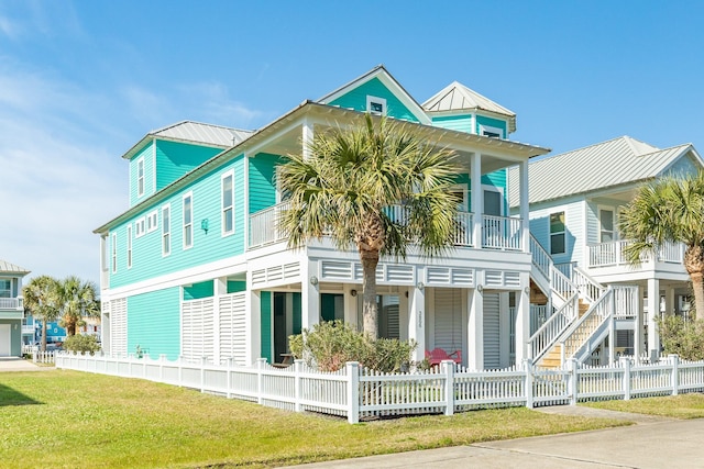 view of front facade featuring metal roof, a fenced front yard, and a front yard