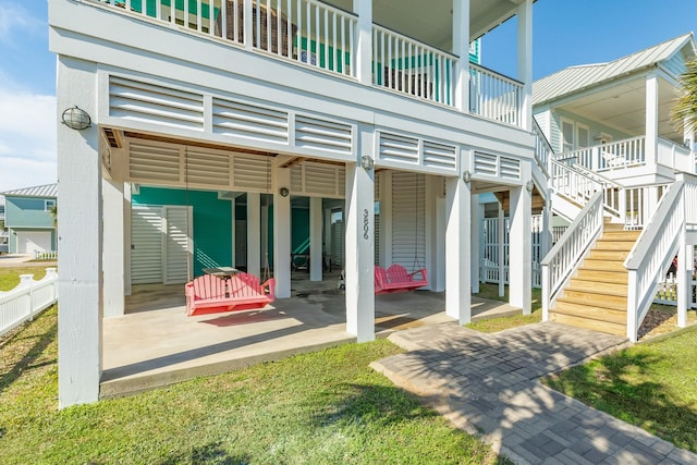 rear view of house featuring a patio area, fence, and stairs