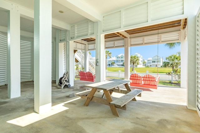 view of patio / terrace with a residential view, stairway, fence, and outdoor dining space