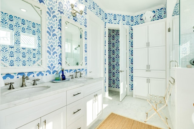 full bathroom with crown molding, double vanity, a sink, and wallpapered walls