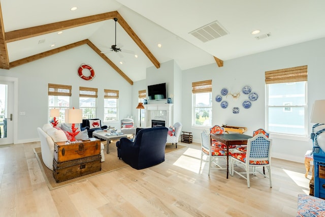 living room featuring light wood-style flooring, visible vents, and a healthy amount of sunlight