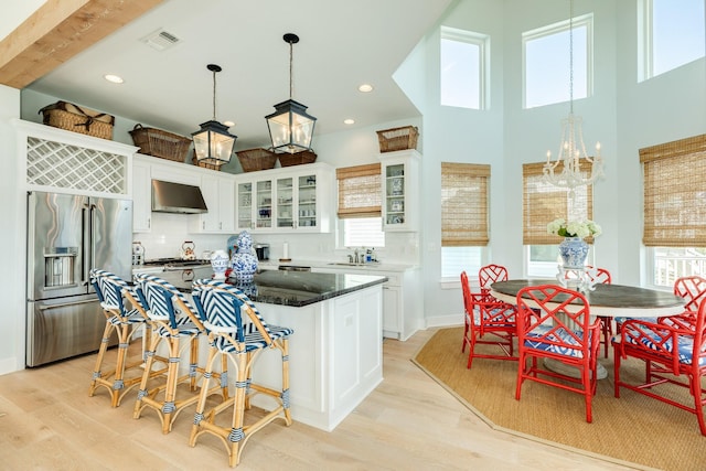 kitchen featuring white cabinetry, high quality fridge, visible vents, and extractor fan