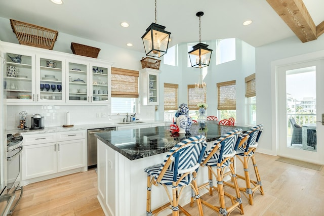 kitchen featuring stainless steel appliances, a breakfast bar, a sink, and light wood-style flooring