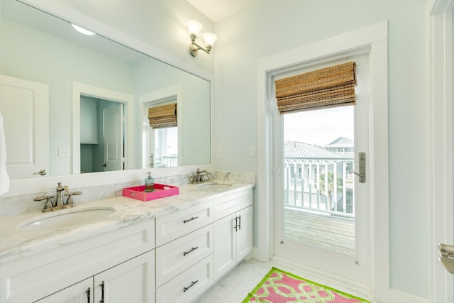 full bathroom with marble finish floor, a sink, and a healthy amount of sunlight