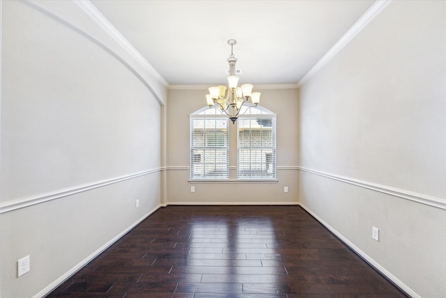 empty room featuring a chandelier, baseboards, wood finished floors, and ornamental molding