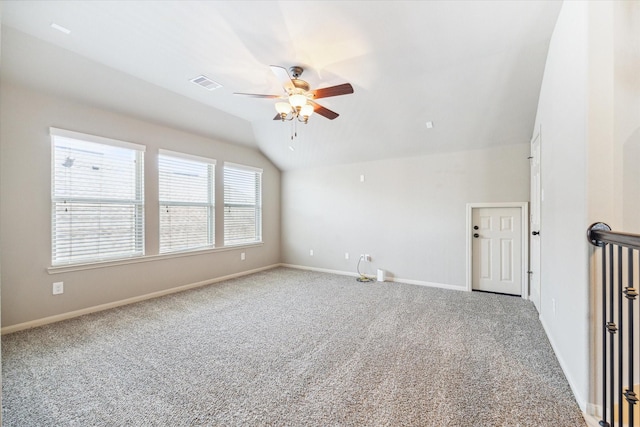 carpeted spare room featuring visible vents, baseboards, a ceiling fan, and vaulted ceiling