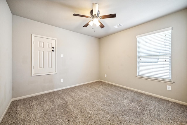 spare room with visible vents, a ceiling fan, baseboards, and carpet floors