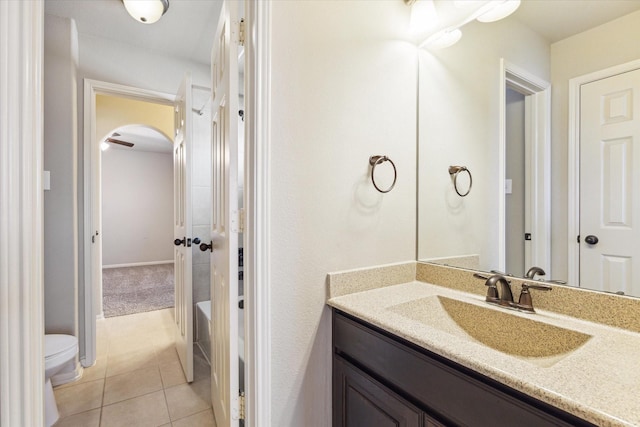 full bath featuring a bathtub, toilet, vanity, and tile patterned flooring