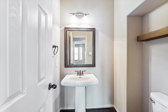 bathroom with toilet and baseboards