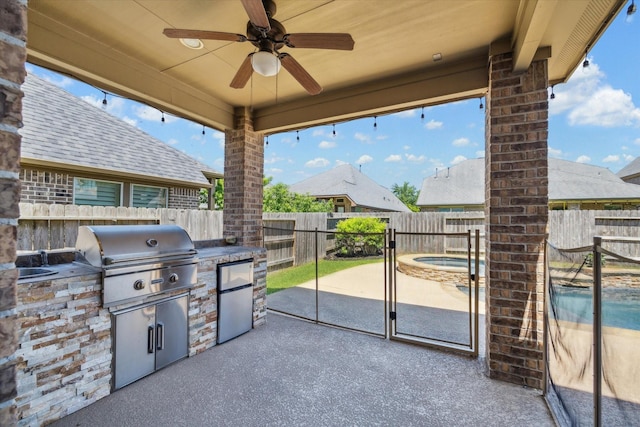 view of patio with an outdoor kitchen, a fenced backyard, grilling area, ceiling fan, and a hot tub