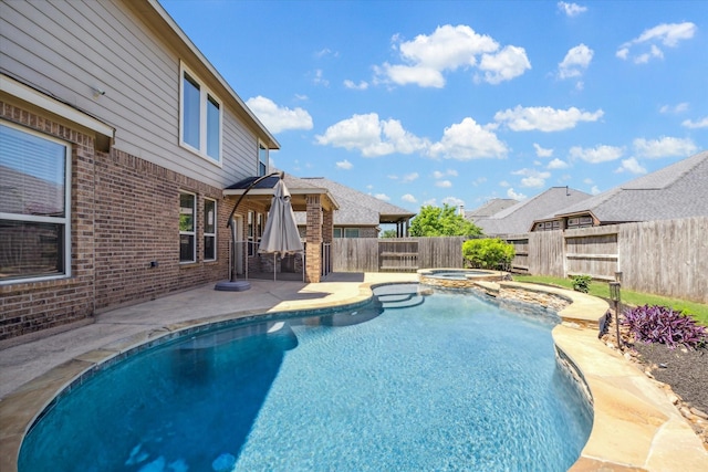 view of swimming pool with a patio area, a pool with connected hot tub, and a fenced backyard