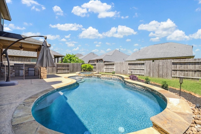 view of swimming pool with a fenced in pool, exterior kitchen, a fenced backyard, an in ground hot tub, and a ceiling fan