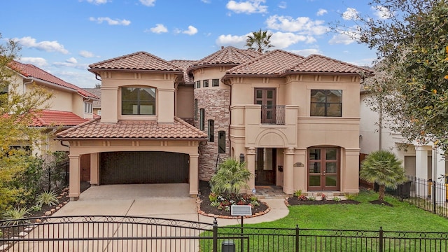 mediterranean / spanish home with a fenced front yard, stucco siding, concrete driveway, a balcony, and a tiled roof