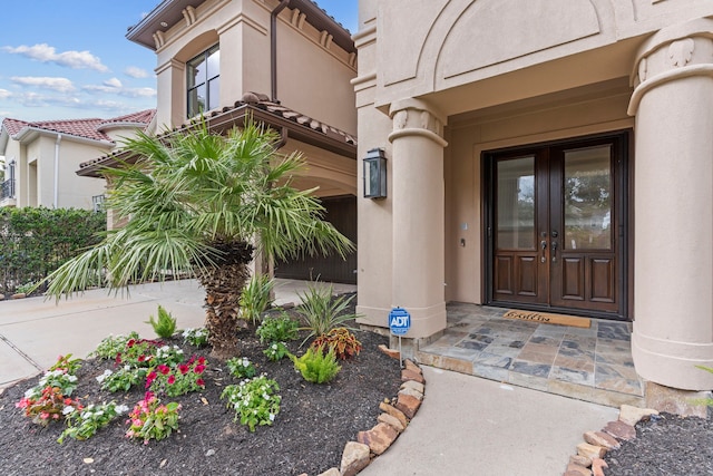 view of exterior entry with french doors and stucco siding