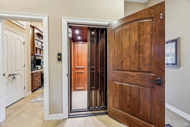 interior space with light tile patterned floors and baseboards