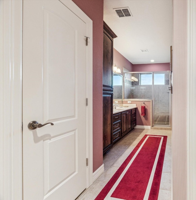 bathroom with a stall shower, visible vents, vanity, and tile patterned floors