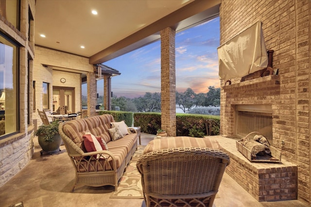 patio terrace at dusk with an outdoor living space with a fireplace