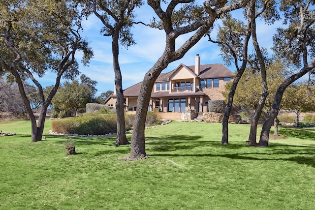 view of front of house featuring a chimney and a front yard