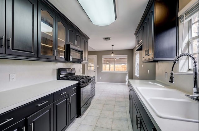 kitchen with visible vents, light countertops, light tile patterned floors, black appliances, and a sink