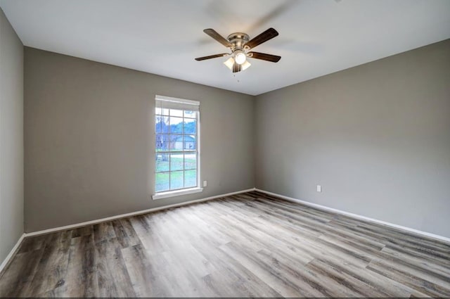 empty room featuring baseboards, a ceiling fan, and wood finished floors